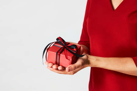 Woman hands holding small gift box with ribbon on white background. Christmas, New Year, Valentine's day and birthday conceptの写真素材