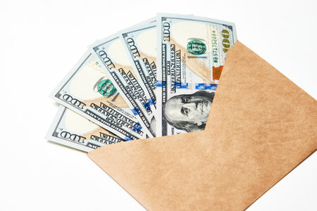 Paper Envelope with money, close-up. Dollar money in an envelope isolated on white. Salary, earning and savings conceptの写真素材