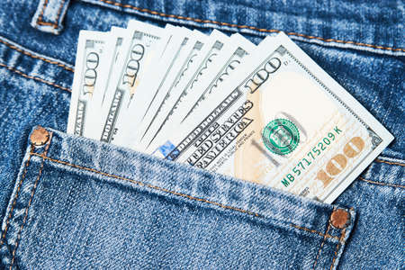 Jeans pocket with money, close-up. Blue jeans pocket with hundred dollars banknotesの写真素材