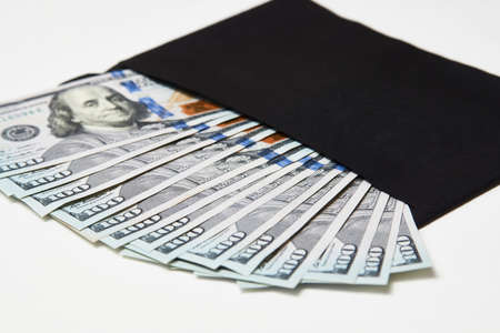 Black Envelope with money, csloe-up. Dollar money in an envelope isolated on white. Salary, earning and savings conceptの写真素材