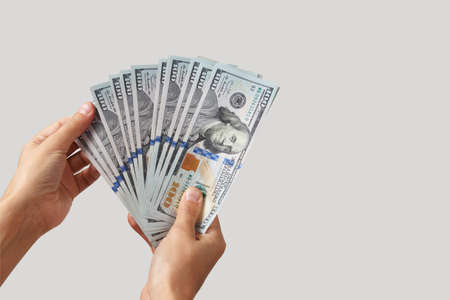Hand with money isolated on white background with copy space. Woman hand giving dollar money, close-upの写真素材