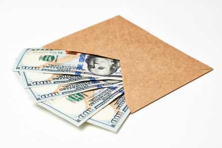 Paper Envelope with money, close-up. Dollar money in an envelope isolated on white. Salary, earning and savings conceptの写真素材