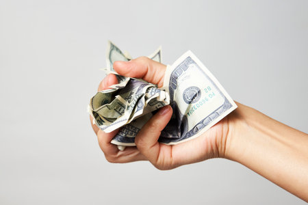 Hand with money isolated on white background with copy space. Woman hand holding dollar money, close-upの写真素材