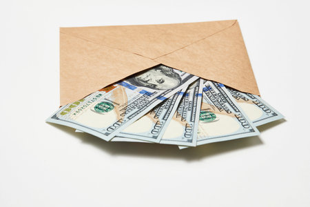 Paper Envelope with money, close-up. Dollar money in an envelope isolated on white. Salary, earning and savings conceptの写真素材