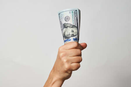 Hand with money isolated on white background with copy space. Woman hand giving dollar money,...