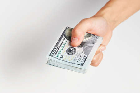 Hand with money isolated on white background with copy space. Woman hand giving dollar money, close-upの写真素材