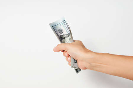 Hand with money isolated on white background with copy space. Woman hand giving dollar money, close-upの写真素材