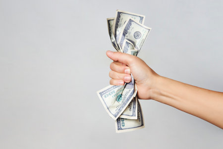 Hand with money isolated on white background with copy space. Woman hand holding dollar money, close-upの写真素材