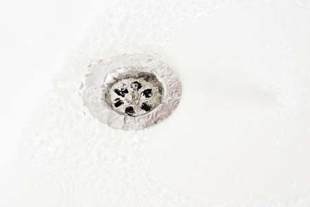 White sink with drain hole, close-up. Water drain top viewの写真素材
