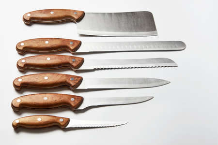 Kitchen knives on white background. Set of steel knives with wooden handle