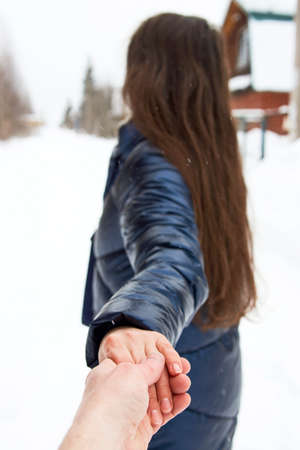 Beautiful woman in a winter forest enjoying first snow, outdoorの写真素材