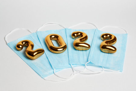 Coronavirus prevention concept with 2022 new year and medical mask on white background