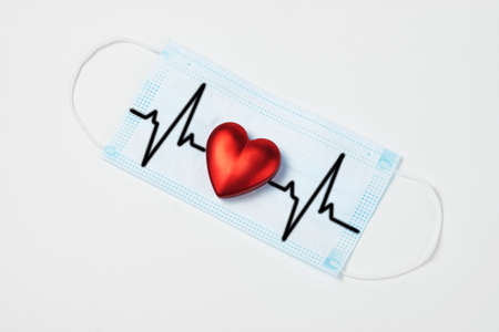 Medical face mask and red heart on white background. Healthcare and medical concept. Coronavirus...