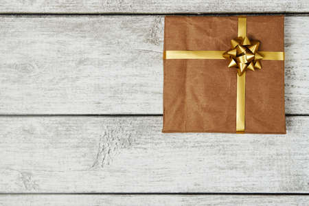 Gift boxes wrapped in craft paper with bow tie on wooden background with copy spaceの写真素材
