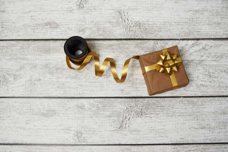 Gold ribbon for gift box wrapping on wooden background with copy space, top viewの写真素材