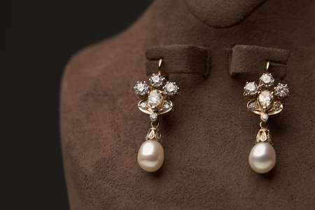 Diamond earrings with pearl, background. Luxury female jewelry, close-up. Selective focusの写真素材