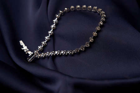 Platinum bracelet with diamonds on background. White gold bracelet with gemstones, close-up,...