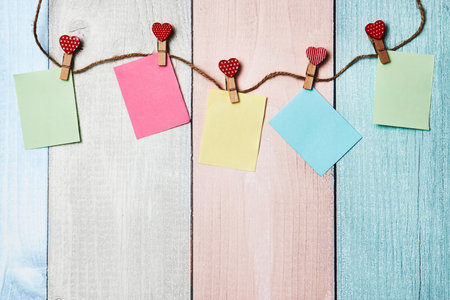 Red hearts on rope with clothespins and note paper, on a background with copy space for text. Valentines day backgroundの写真素材