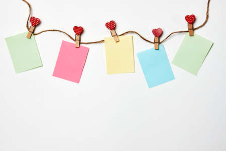 Red hearts on rope with clothespins and note paper, on a background with copy space for text....