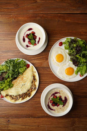 Restaurant breakfast table served with omelette fresh juice and porridge