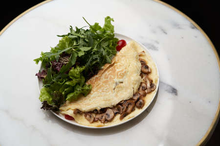 Breakfast oatmeal pancakes with frying mushrooms and salad leaves. Healthy vegetarian foodの写真素材