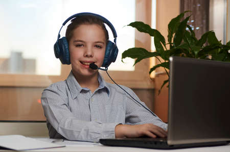 Online learning and distance study concept. Teenage boy enjoy e-learning on computer notebook.の写真素材