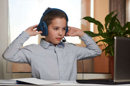 Online learning and distance study concept. Teenage boy enjoy e-learning on computer notebook.