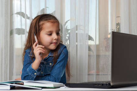 Preschool education. Child girl enjoy e-learning on computer notebook. Online learning and distance study concept.の写真素材