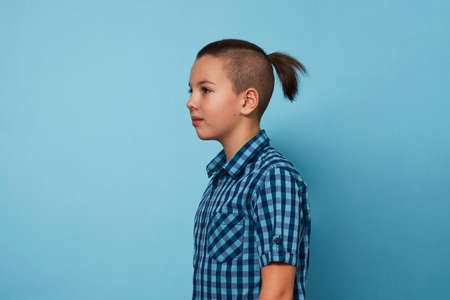 Handsome boy portrait with stylish hairstyle over blue background. Fashionable child hairstyle