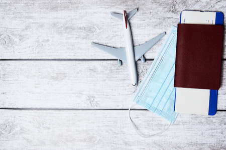 Traveling during pandemic. Passport, protective face mask and plane. virus and travel conceptの写真素材