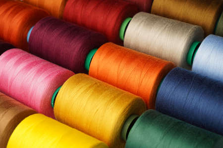 Colorful thread spool background, close-up. Multi Colored threads for sewing and needlework