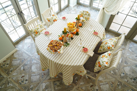 Table with orange cookies, fruits snacks. Table setting with tablecloth  and food