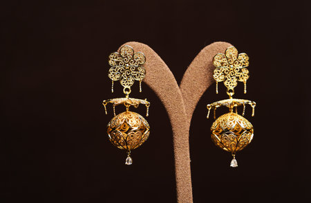 Golden earrings on brown background. Luxury vintage jewelry, close-upの写真素材