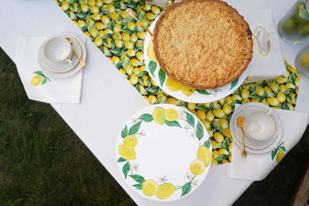 Table with apple pie, fruits snacks. Table setting with tablecloth and food. Spring concept