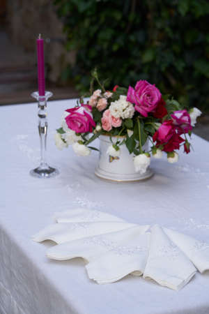 Beautiful table setting with napkin. Table decoration with plate, napkin and candleの写真素材
