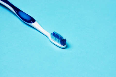 Tooth and toothbrush on blue background with copy space. Dental health and oral hygiene conceptの写真素材