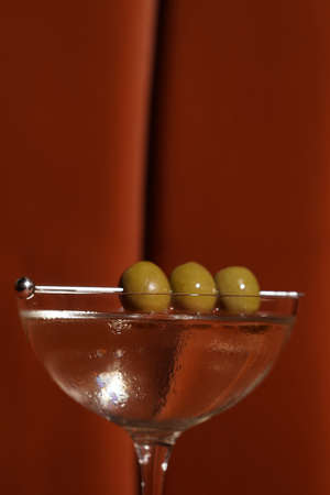 Classic cocktail glass on table in night club restaurant. Martini glass cocktail with olives,...