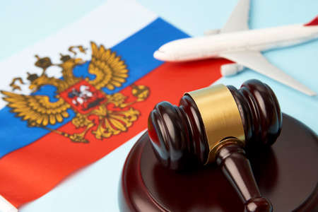 Sanctions in Russian aviation concept. Flag of Russia with judge gavel and plane on blue background, close-upの写真素材