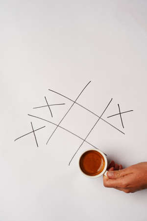Coffee cup and cookies as breakfast with tic-tac-toe game. Coffee break concept, top view