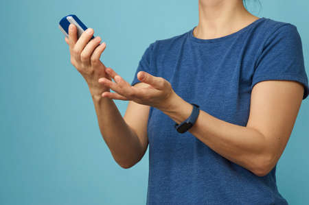 Woman checking blood sugar level with glucometer. Young woman doing diabetes test