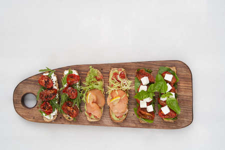 Traditional italian bruschetta. Variety of bruschetta toast. Various sandwiches on wooden board...