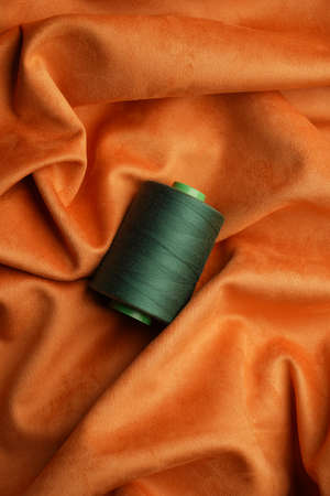 Green thread spool background, close-up. Green threads for sewing and needlework