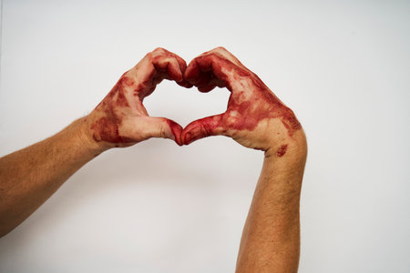 Bloody hand making heart shape isolated on white background isolated on white background with copy space, close-upの写真素材