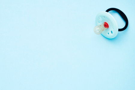 Baby pacifier on a blue background with copy space.