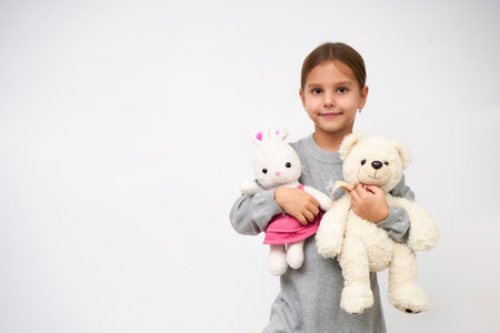 Portrait of little girl with white toy bear. Little girl holding teddy bear on white background with copy spaceの写真素材