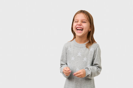 Cute little girl laughing on white background with copy space. Portrait of a smiling child girl, close-upの写真素材