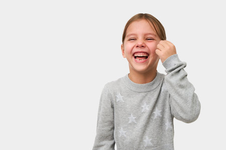 Cute little girl laughing on white background with copy space. Portrait of a smiling child girl, close-upの写真素材