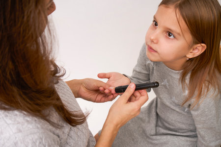 Woman checking diabetes to daughter girl. Children and diabetes conceptの写真素材