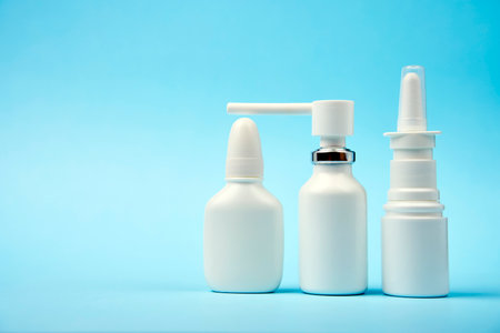 Nasal spray bottle on blue background with copy space. White plastic medical spray bottle, close-upの写真素材