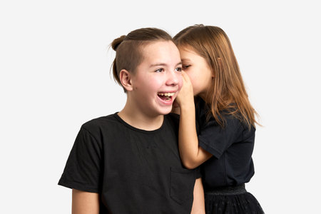 Brother and sister kids having fun. Portrait of teenage boy and preschool girl playing together on white backgroundの写真素材